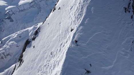Luftaufnahme-Eines-Professionellen-Skifahrers,-Der-An-Einem-Sonnigen-Tag-Auf-Einem-Verschneiten-Steilhang-Des-Berges-Wartet