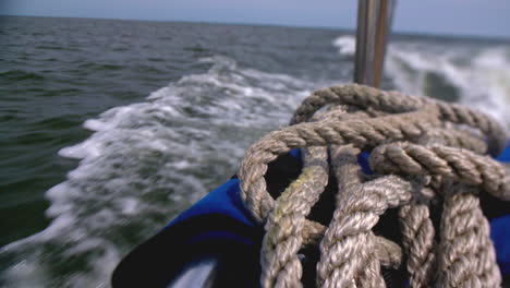 View-from-the-stern-of-a-sailboat-while-sailing-at-sea-on-a-sunny-day,-copy-space