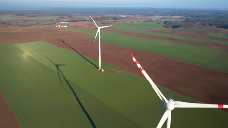 Panoramic-aerial-view-of-wind-farm-or-wind-park-on-sunny-day,-with-high-wind-turbines-for-generation-electricity