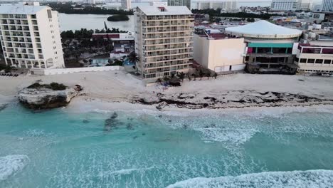 Aerial-horizontal-movement-across-the-beaches-of-Cancun,-Mexico's-hotel-zone-during-sunrise