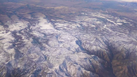 Glorious-Mountain-Country-From-an-Airplane-Window-With-Clouds-during-Travel-on-a-Flight