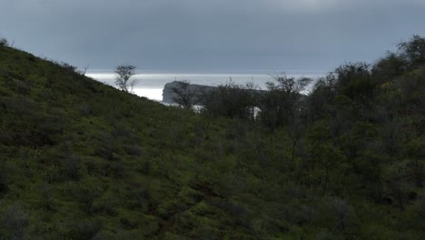 Cinematic-Reveal-Of-Molokini-Crater,-Aerial-Crane-Shot-Slowly-Ascending-Over-Pu'u-Ola'i-Summit-In-The-Southern-Coast-Of-Maui