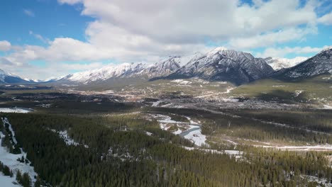 Aerial-pan-of-Canmore,-Alberta,-Canada-and-mountains