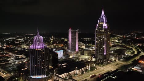 Wide-view-of-downtown-Mobile,-Alabama-at-night-with-drone-video-moving-in-a-circle