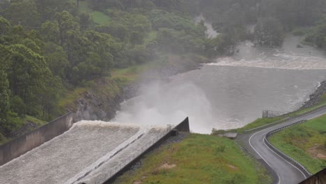 Handheld-shot-of-Hinze-Dam-outflow-under-heavy-rain-and-water-flows-during-La-Niña,-Gold-Coast-Hinterland,-Queensland,-Australia
