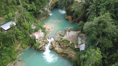 Canyoneering-Travelers-arriving-Kawasan-Falls,-people-swimming-in-turquoise-blue-water-of-multi-layered-waterfall