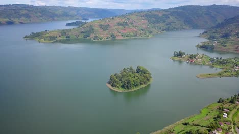Pequeña-Isla-Con-Una-Montaña-En-Terrazas-Al-Fondo-En-El-Lago-Bunyonyi,-Uganda,-áfrica