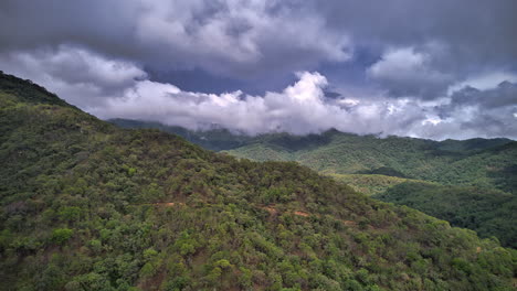 Hyperlapse-featuring-a-hill-in-the-foreground,-with-dramatic-fast-moving-clouds,-unveiling-the-Sierra-Madre-Occidental-mountain-range