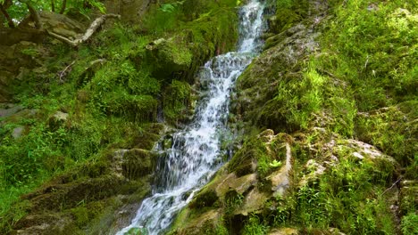 Maries-Waterfall,-Surrounded-By-Lush-Green-Vegetation-And-Rocks-Covered-By-Moss,-Sun-Rays,-Thassos-Island,-Greece