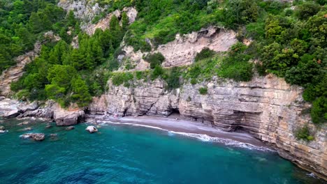 Flying-Towards-The-Rocky-Cliffs-With-Tourist-On-The-Seashore-In-Amalfi-Coast,-Campania-Italy