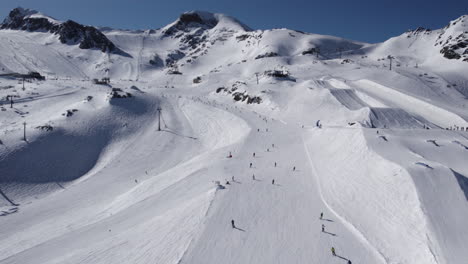 Luftaufnahme-Vieler-Skifahrer,-Die-In-Der-Sonne-Schneebedeckte-Berge-Hinunterfahren---Österreich,-Europa