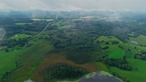 Luftaufnahmen-über-Den-Wolken-Und-Eine-Wunderschöne-Grüne-Landschaft-Mit-Grasland-Und-Bäumen
