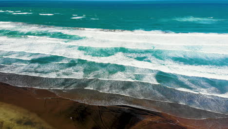 Stunning-Piha-Beach-With-Person-Kite-Boarding-In-New-Zealand