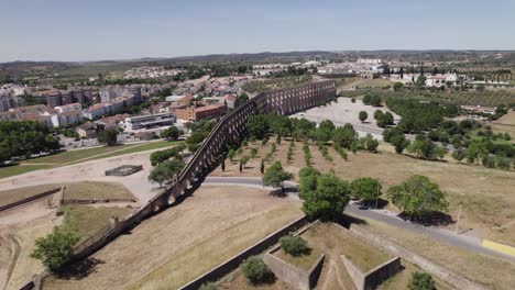 Wide-aerial-pull-out-of-Amoreira-Aqueduct-in-sunny-Elvas,-Portugal