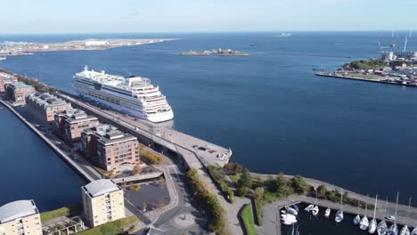Elegant-cruiser-parked-in-modern-Langelinie-dock-next-to-marina-on-bright-summer-day-in-Copenhagen,-aerial-view