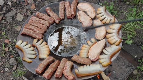 Person-grilling-Szalonna-and-Mititei,-traditional-Transylvanian-food-over-wood-fire