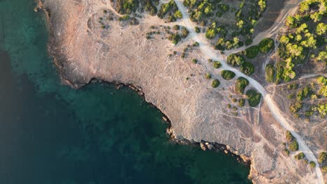 Overhead-View-Of-Rock-Cliffs-With-Vegetation-On-The-Summer-Beach-Near-Sa-Coma-In-Mallorca,-Spain