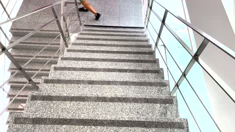 fit-woman-gracefully-descends-the-stairs-in-the-gym,-making-her-way-to-the-shower-area