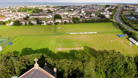 Kids-are-playing-cricket-behind-the-church-aerial-birds-eye-view-drone-shot