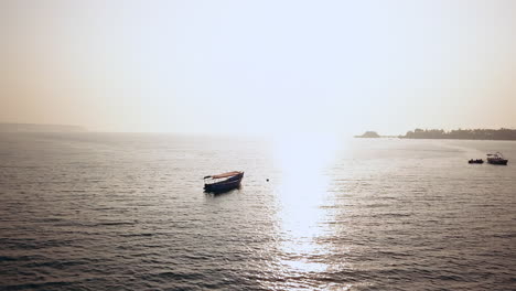 Catamarán-Estacionado-En-India-Playa-Tropical-Vista-De-Goa-En-La-Bahía-Del-Mar-Arábigo-Océano-índico-Puesta-De-Sol-De-Playa-Movimiento-De-Círculo-Cinematográfico-Aéreo