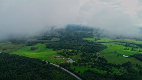 Alta-Filmación-De-Drones-De-Un-Paisaje-Verde-Bajo-Una-Cubierta-De-Nubes