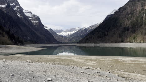 Static-view-of-suggestive-alpine-lake-inside-mountains-with-an-happy-dog-playing