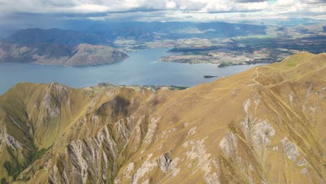 Amazing-aerial-high-rise-scenic-over-Roys-Peak-summit,-Lake-Wanaka-famous-travel-destination-in-New-Zealand