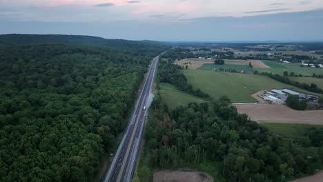 An-aerial-view-of-traffic-on-a-highway-in-the-late-evening-light-with-the-last-color-of-the-sunset-leaving-the-sky