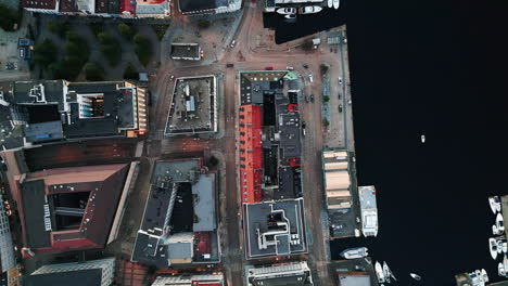 Aerial-view-over-residential-area-near-the-river,-boats-on-water,-car-traffic-on-roads,-captured-in-Bergen,-Norway