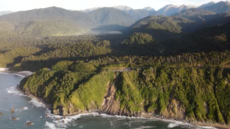 Amazing-aerial-view-of-wild-West-Coast-scenery-of-rainforest-and-shoreline-with-cliffs,-Knights-Point,-South-Island,-New-Zealand
