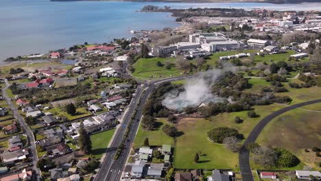 Stunning-aerial-cityscape-reveal-of-Rotorua-city-on-lake,-New-Zealand
