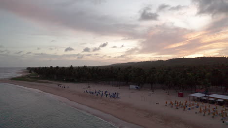 AERIAL---Sunset-at-Falesias-do-Gunga-beach,-Alagoas,-Brazil,-forward-rising