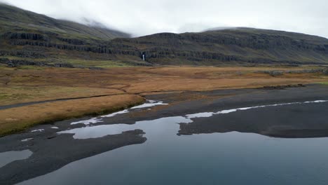 Vista-De-Drones-Volando-Hacia-Una-Cascada-Distante,-Antena-De-Naturaleza-Islandesa