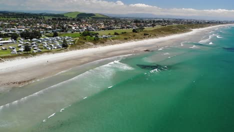 Papamoa-Beach-Holiday-Park-with-Campervans-at-beachfront-aerial-reveal