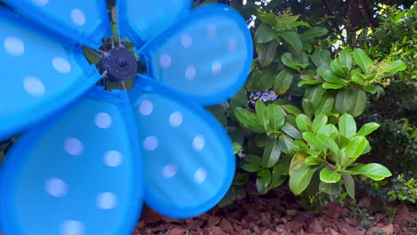 Close-up,-blue-pinwheel-spinning-quickly-from-blowing-wind