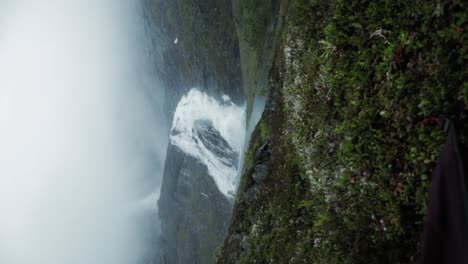 Reveal-of-Husedalen-waterfall-from-inside-tent,-vertical-handheld-view