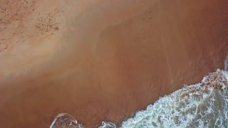 Luftaufnahme-Von-Oben-Nach-Unten:-Türkisfarbene-Wellen,-Die-An-Land-Und-Sandstrand-Im-Atlantischen-Ozean-Krachen