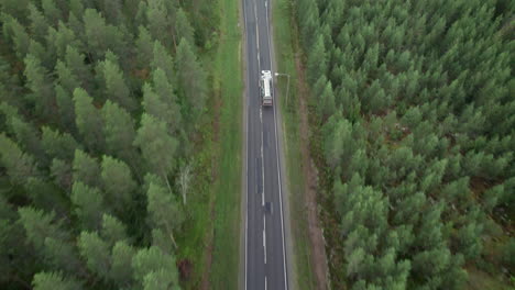 Aerial-Bird-View-of-Forest-Road-in-Finland,-White-Oil-Truck-Passing-By,-Traffic,-Summer,-Overcast-Day