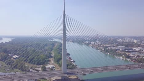 Slow-revealing-4k-aerial-shot-of-Ada-bridge-in-Belgrade,-river-and-lake