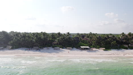Pulling-back-view,-tropical-coast-of-Tulum,-Mexico-and-calm-ocean-with-hotels