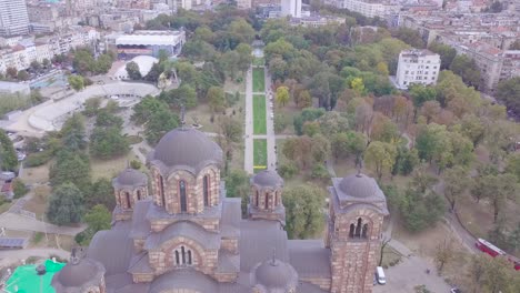 Impresionante-Vuelo-Sobre-El-Parque-Tasmajdan-Y-La-Iglesia-De-San-Marcos,-Belgrado
