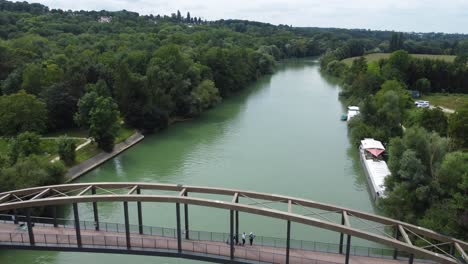 Aerial-shot-of-a-bridge-crossing-a-river-at-Chalifert,-France