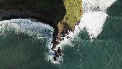 Ocean-waves-crash-on-coastal-cliff-in-Sao-Jorge-Madeira-Portugal-aerial-top-down