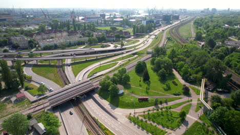 Intersección-Aérea-Y-Carretera-Con-Puentes-Y-Tráfico-En-Gdansk-Durante-El-Día-Soleado---Grúas-Portuarias-Industriales-En-Segundo-Plano