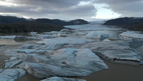 Big-Scattered-Icebergs-Floating-in-Glacier-Lake,-Aerial-Establishing