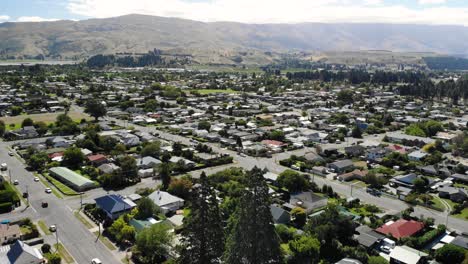 Drone-aerial-view-of-Cromwell,-Central-Otago,-South-Island,-New-Zealand,-valley-town-on-sunny-day