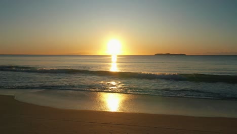 Wunderschöner-Brasilianischer-Strandsonnenaufgang,-Leuchtende-Goldene-Wellen,-Die-In-Richtung-Sandstrandsonnenlicht-Rollen