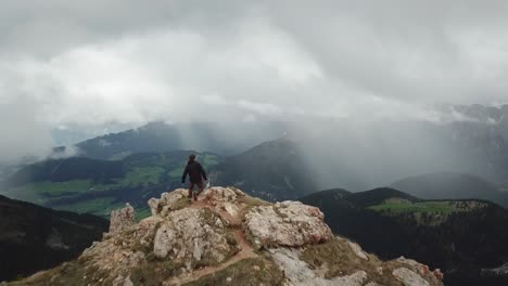 Drone-shot-passing-by-a-running-adventurer-on-top-of-a-mountain-to-reveal-Germany's-beautiful-countryside