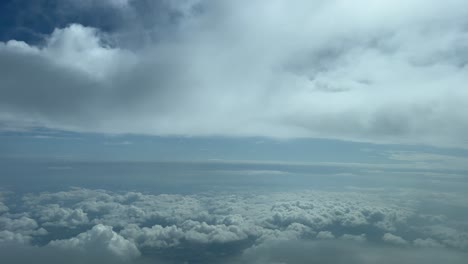 Aerial-view-shot-from-an-airplane-cabin-while-flying-trough-some-fluffy-clouds-at-8000m-high