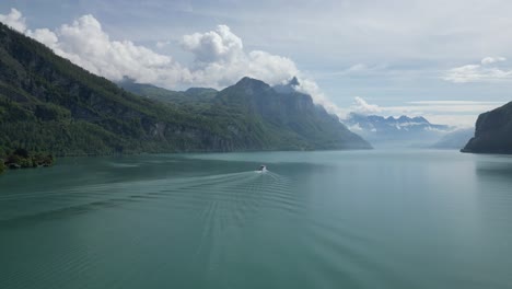 Aerial-view-of-Swiss-scenic-boat-ride-creating-bow-waves-in-Walensee-lake